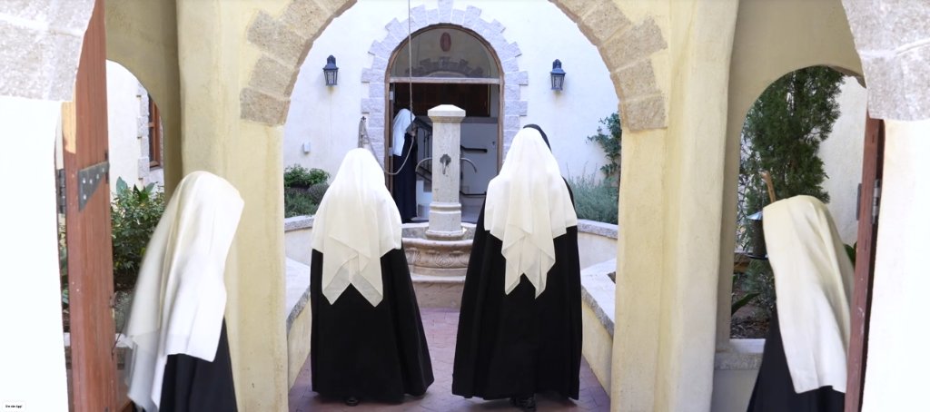 Religious sisters walking through a monastery courtyard